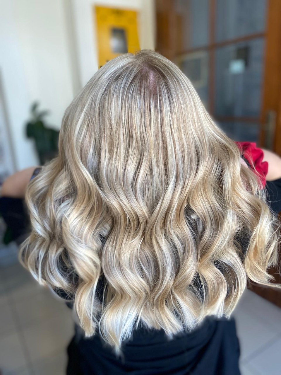 Jasne blond włosy do ramion ułożone w duże fale, widok od tyłu.